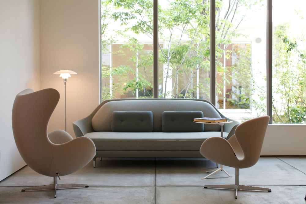 シンプルでミニマムなデザインのソファやラウンジチェアが置かれた土間空間